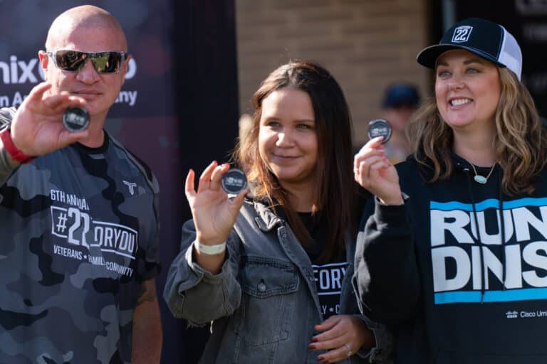 Mission 22 participant displaying event token during a veteran awareness fundraiser.