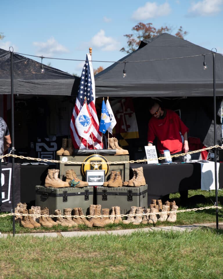 Mission 22 event display featuring military boots, patriotic decorations, and veteran support messaging.