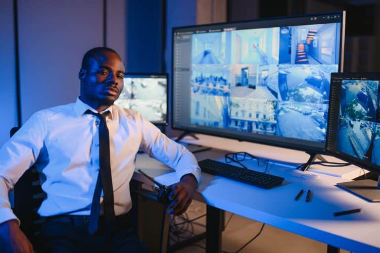 Security professional monitoring security cameral systems and operational data from a command center.